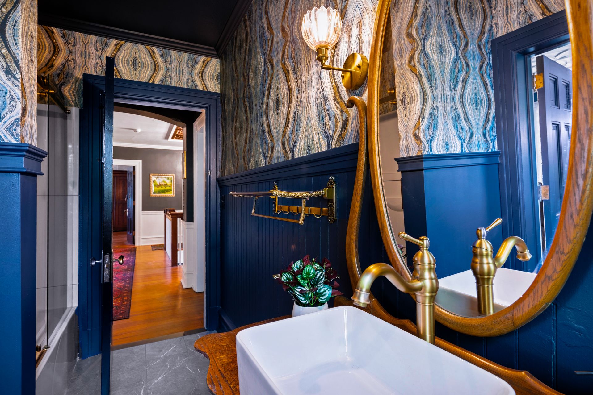 Powder room with brass fixtures and Art Nouveau wallpaper