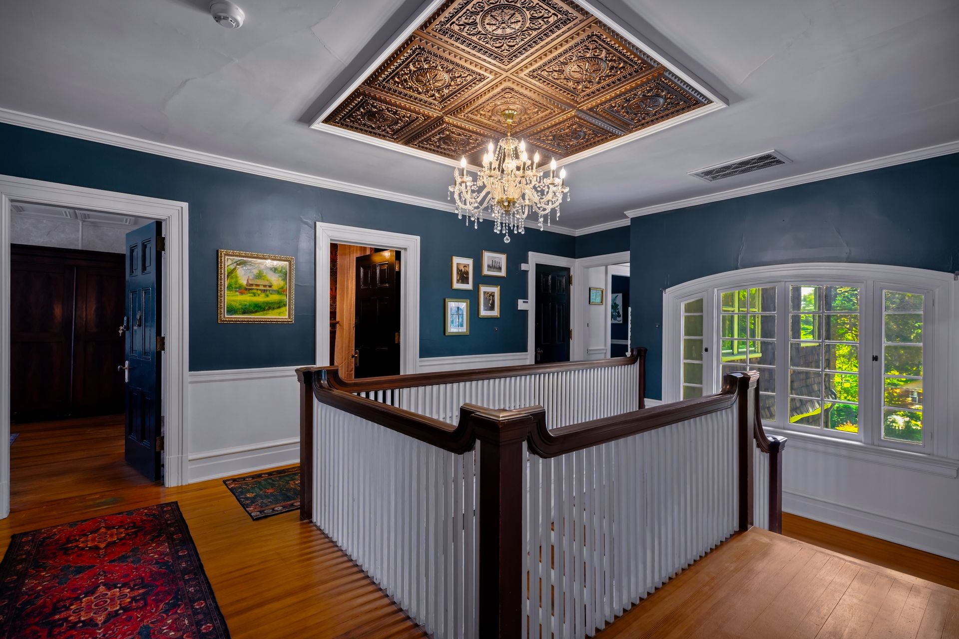 Upstairs landing with ornate tin ceiling and crystal chandelier