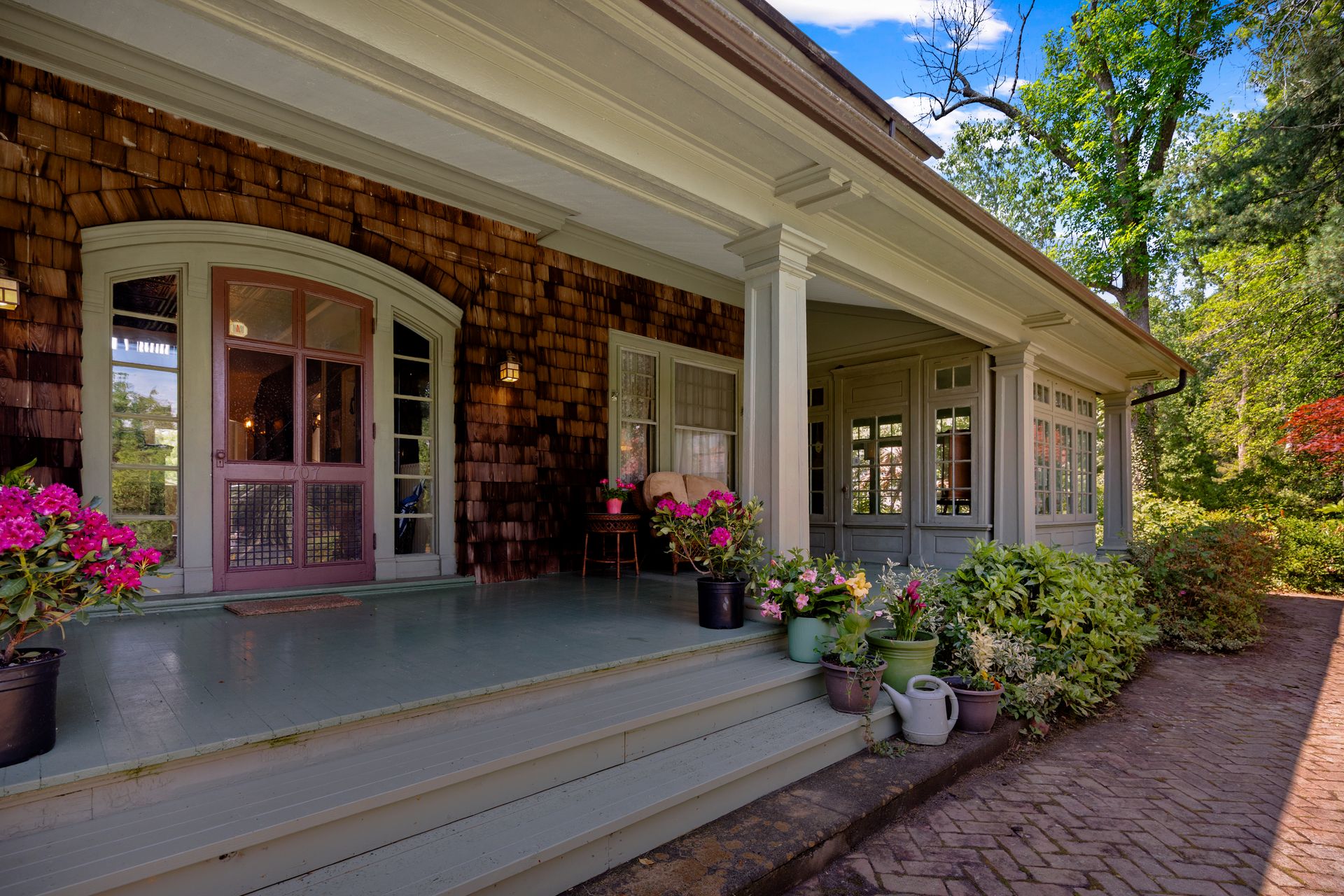 Porch entrance with cedar shingles and arched doors