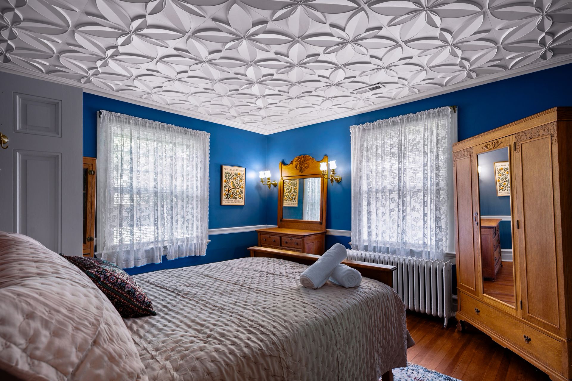 Blue bedroom with light oak furniture and sculptural ceiling